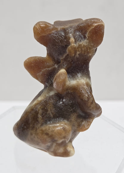 Brown calcite sculpture of a dragon on a white background