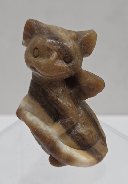 Brown calcite sculpture of a dragon on a white background