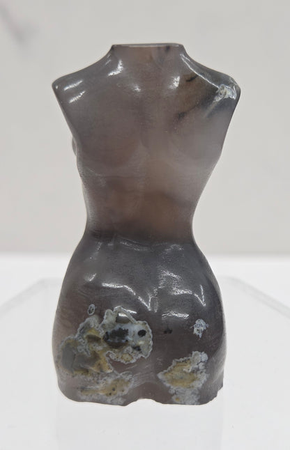 Gray stone sculpture of a woman's torso on a white background