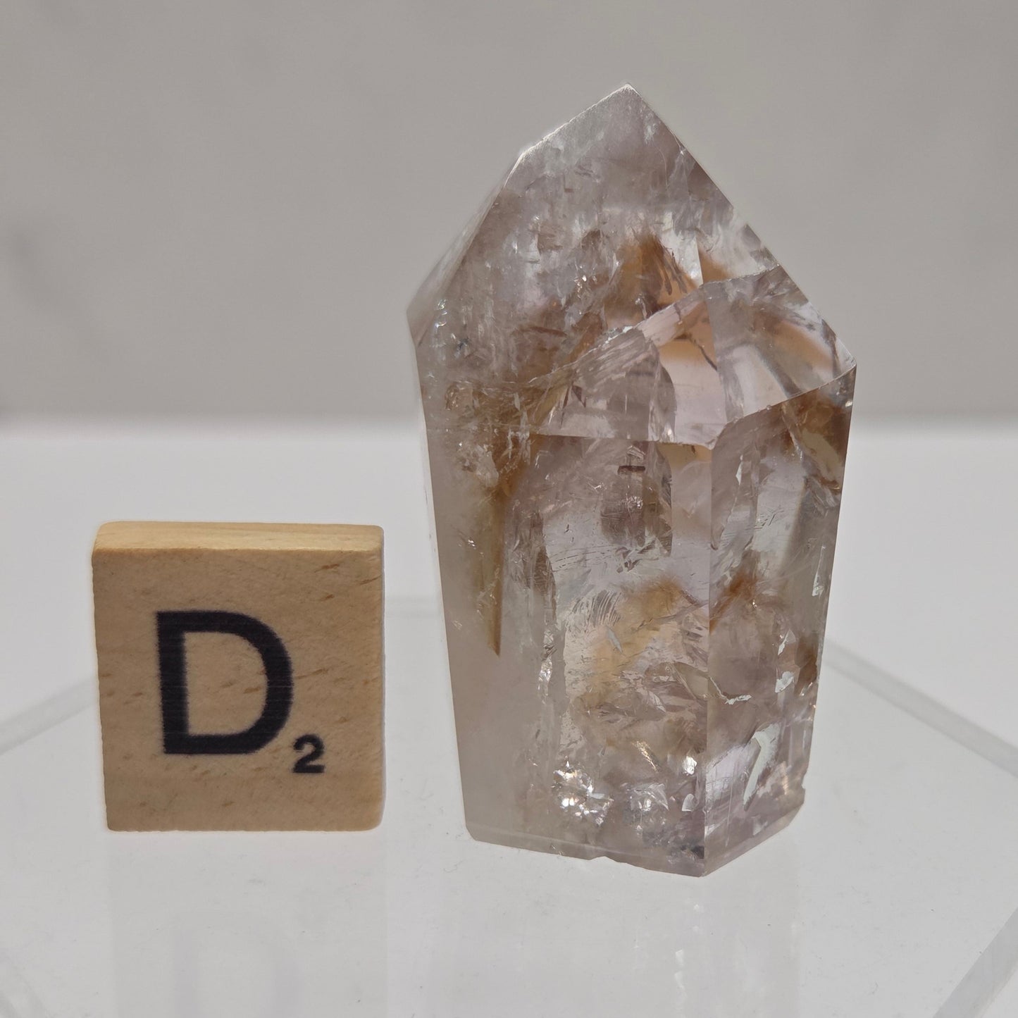 Crystal specimen with a small wooden block labeled 'D2' on a white background