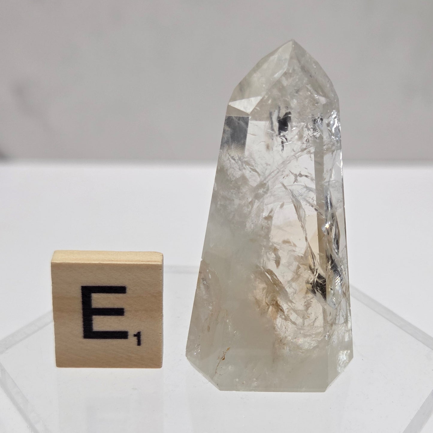 Crystal object with a wooden block featuring a symbol on a white background