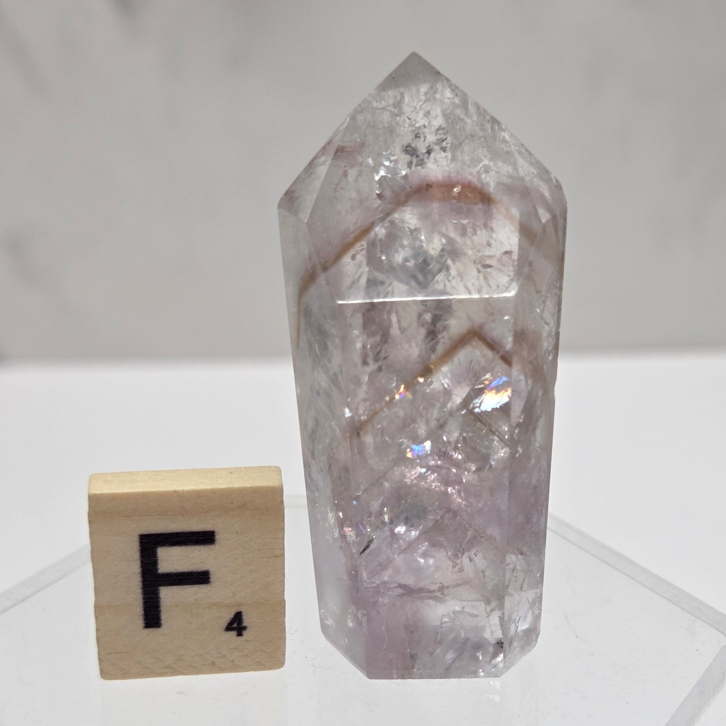 Crystal object and wooden block with letter 'F' on a white background