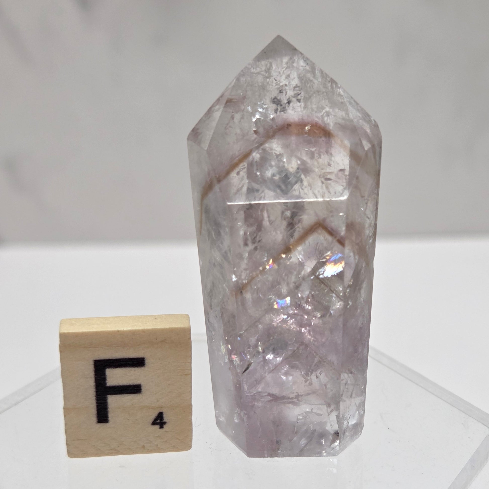 Crystal object and wooden block with letter 'F' on a white background