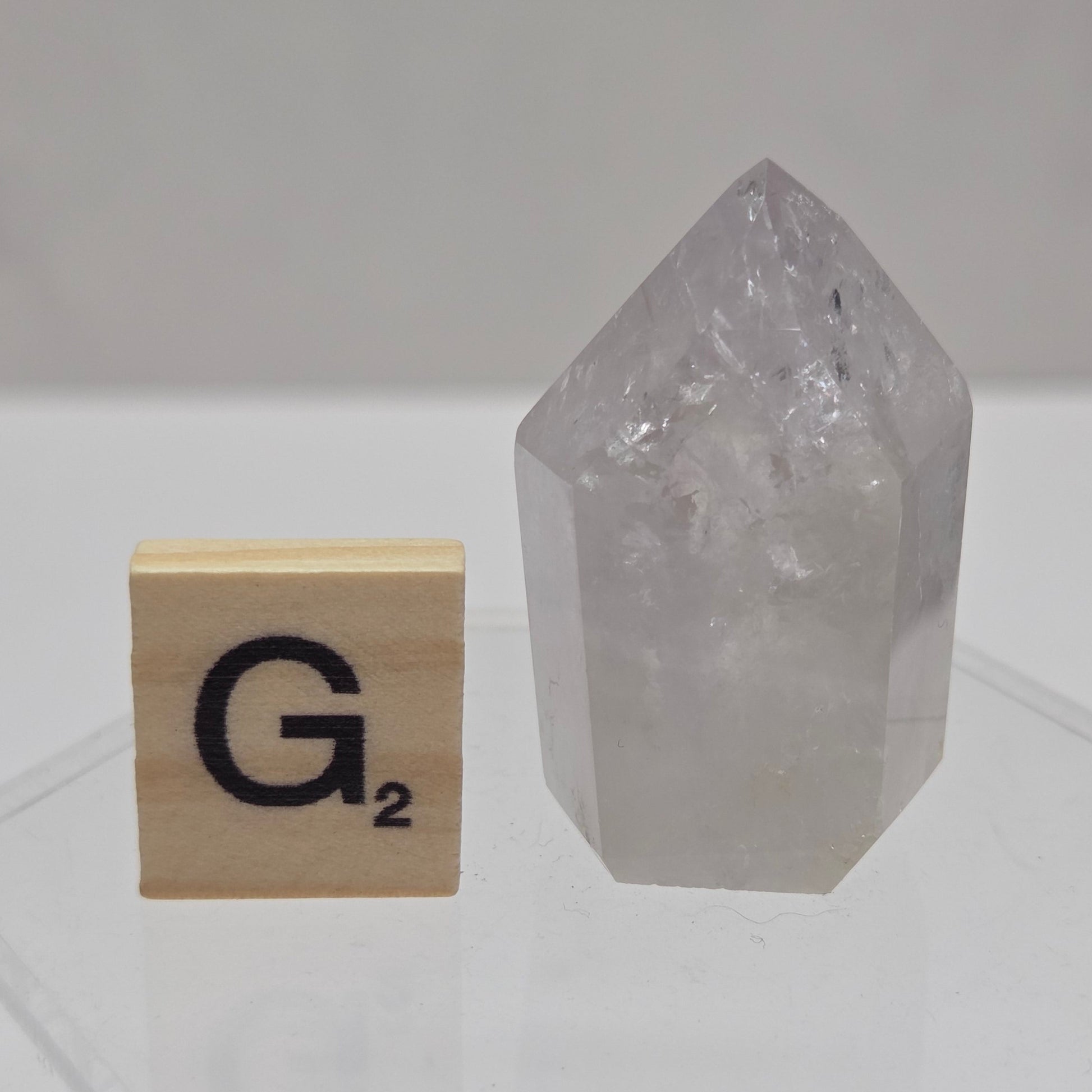 Crystal tower with a wooden block featuring a logo on a geometric-patterned wall.