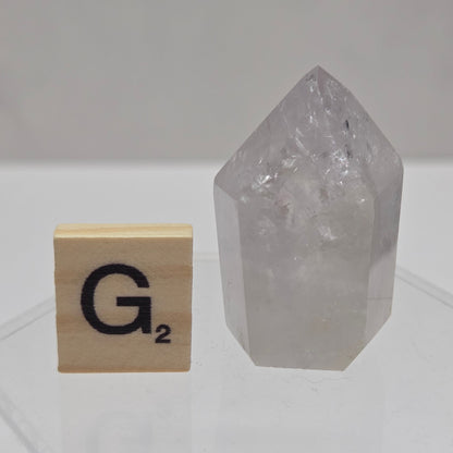 Crystal tower with a wooden block featuring a logo on a geometric-patterned wall.