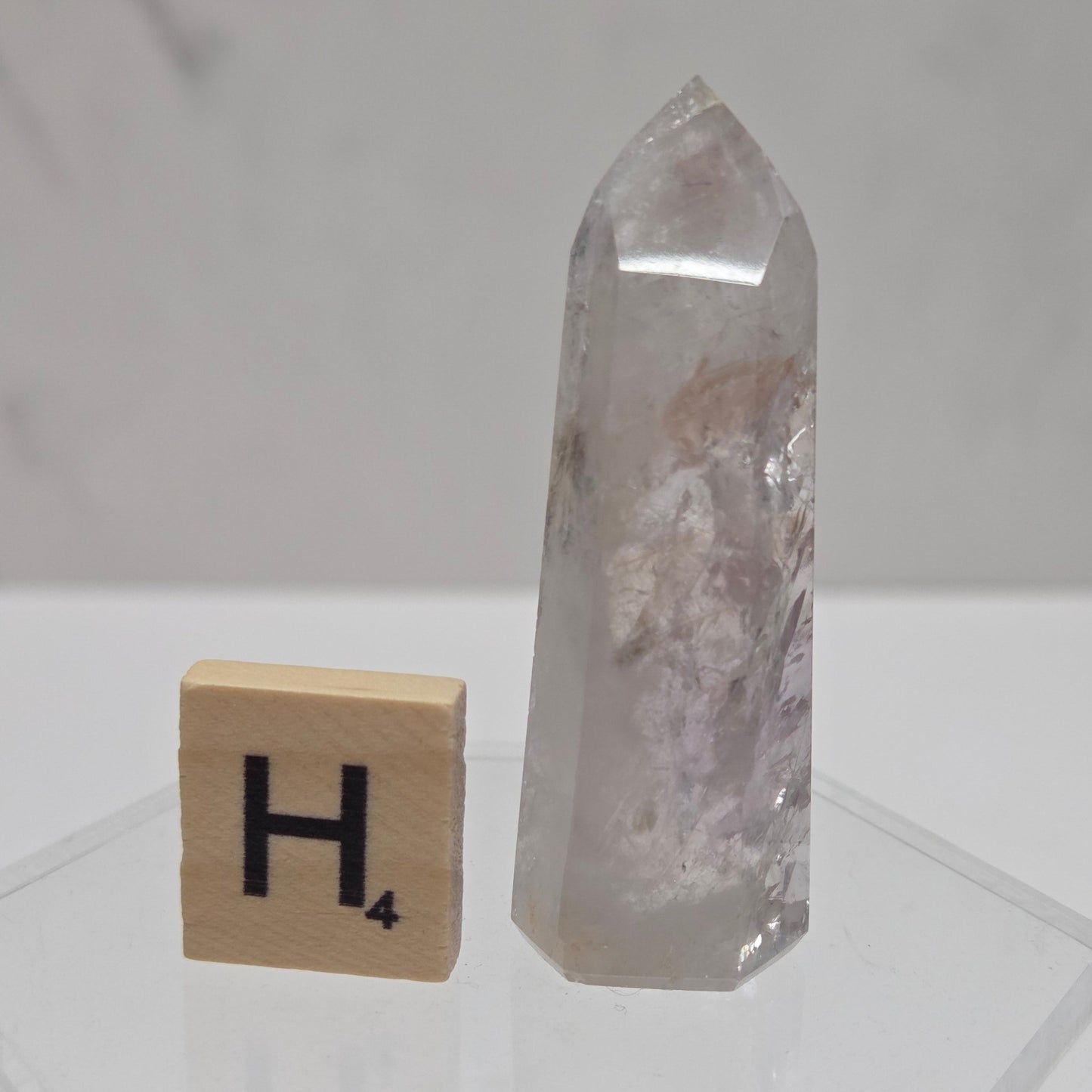Crystal and wooden block with letter 'H' on a white background