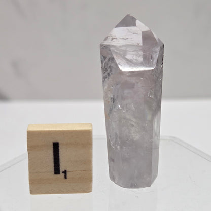 Crystal block and wooden soap dish on a white geometric-patterned wall