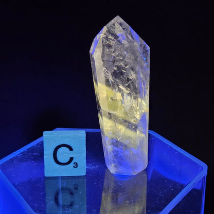 Crystal under UV light with a label on a black background