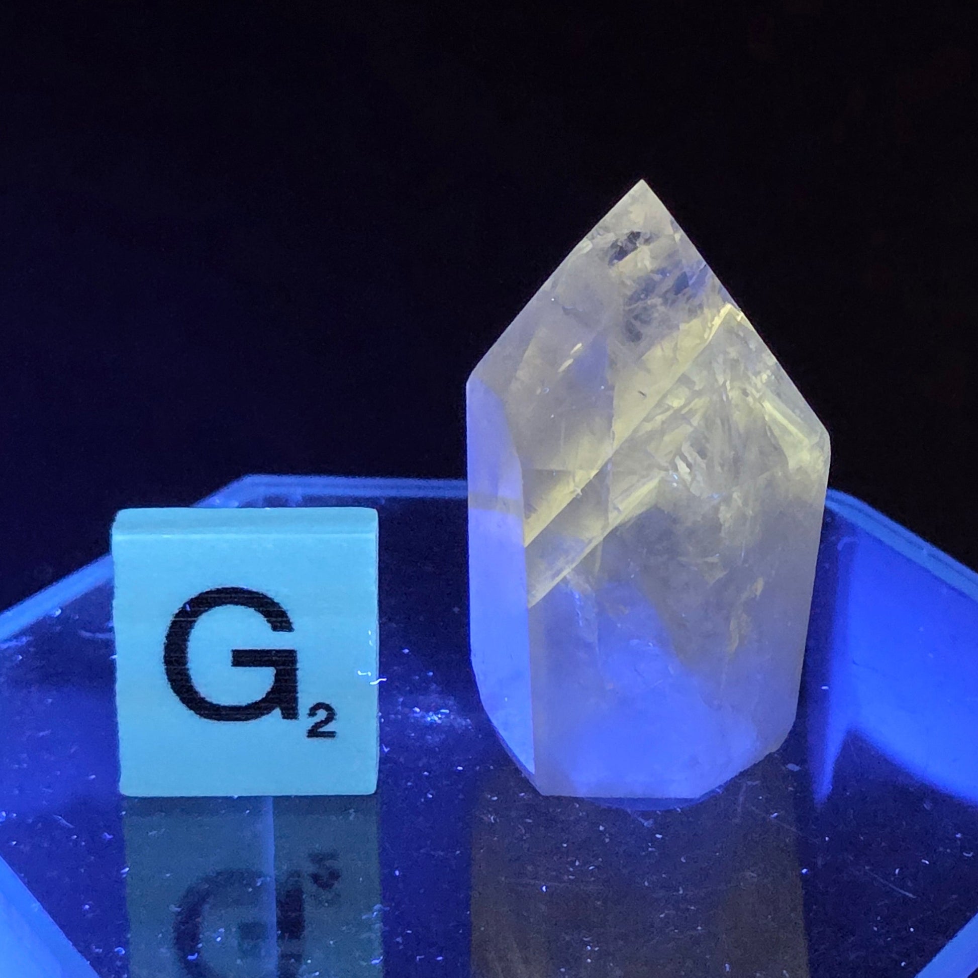Crystal-like object under a blue light with a label 'G2' on a black background