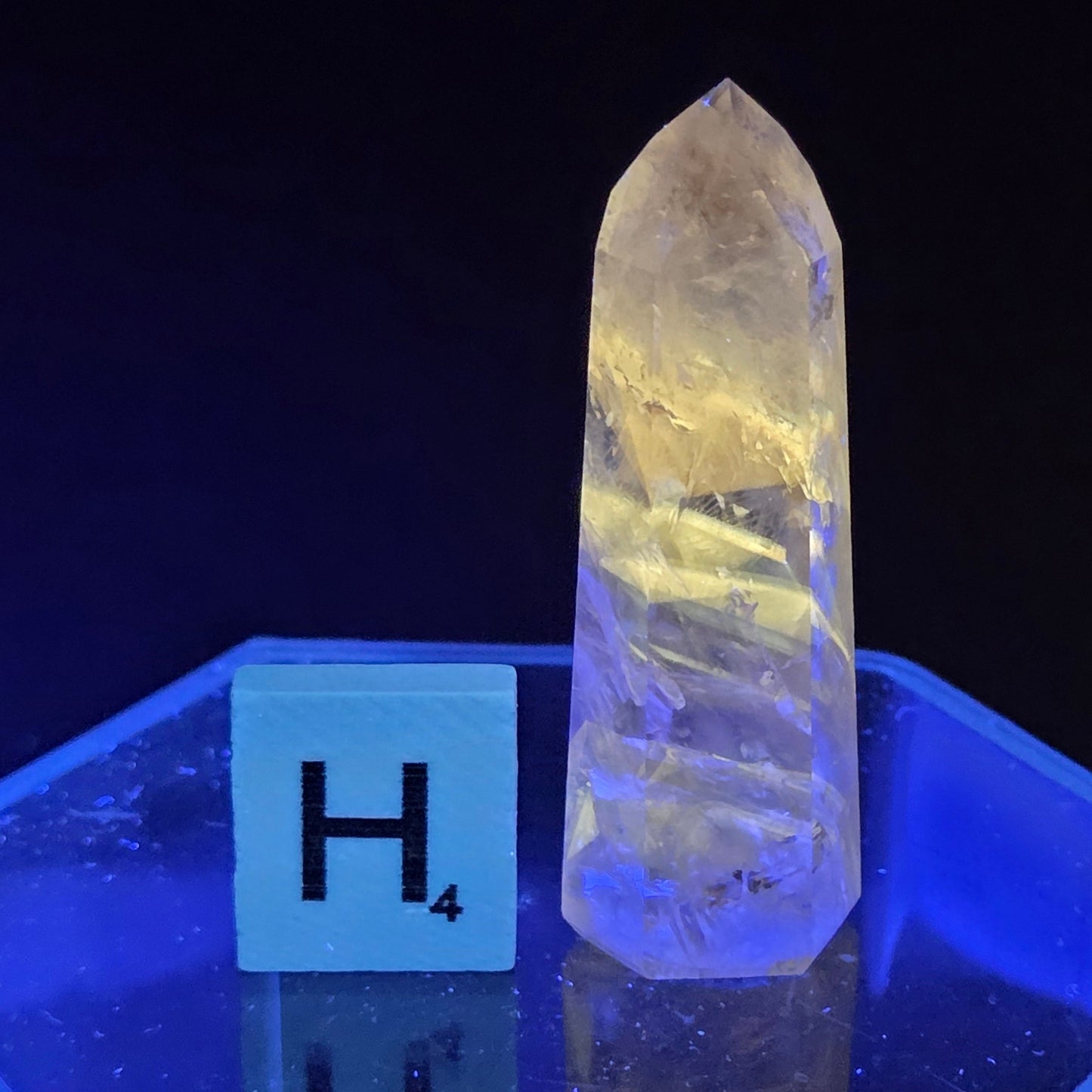 Clear crystal under a blue light with a scale for measurement