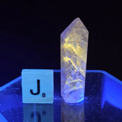 Crystal-like object under a blue light with a label 'J8' in the foreground.