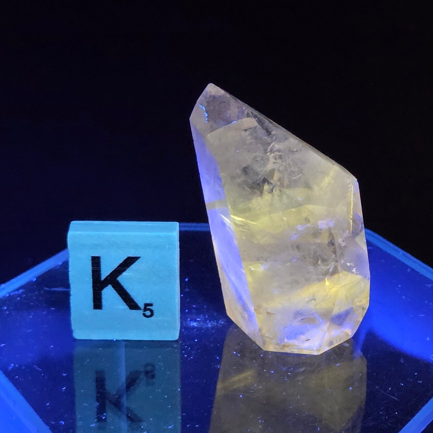 Clear crystal-like object with a blue cube labeled 'K5' on a dark background
