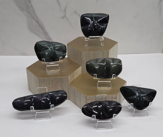 Collection of black crystal stones on clear stands against a marble background