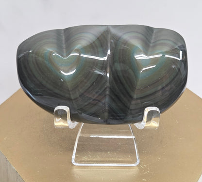 Obsidian carving on an acrylic stand against a neutral background
