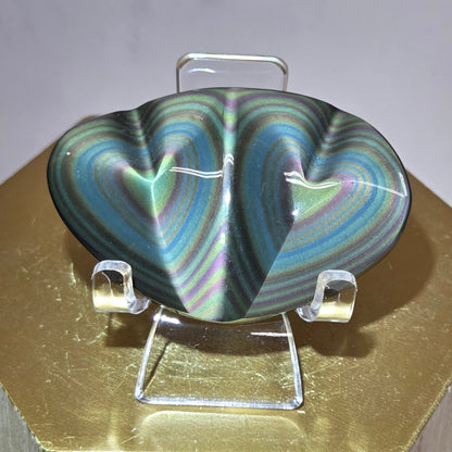Obsidian carving on an acrylic stand against a neutral background