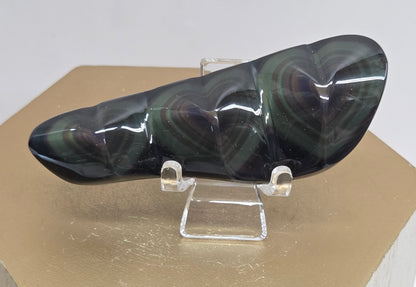 Obsidian carving on an acrylic stand against a neutral background