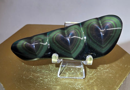 Obsidian carving on an acrylic stand against a neutral background