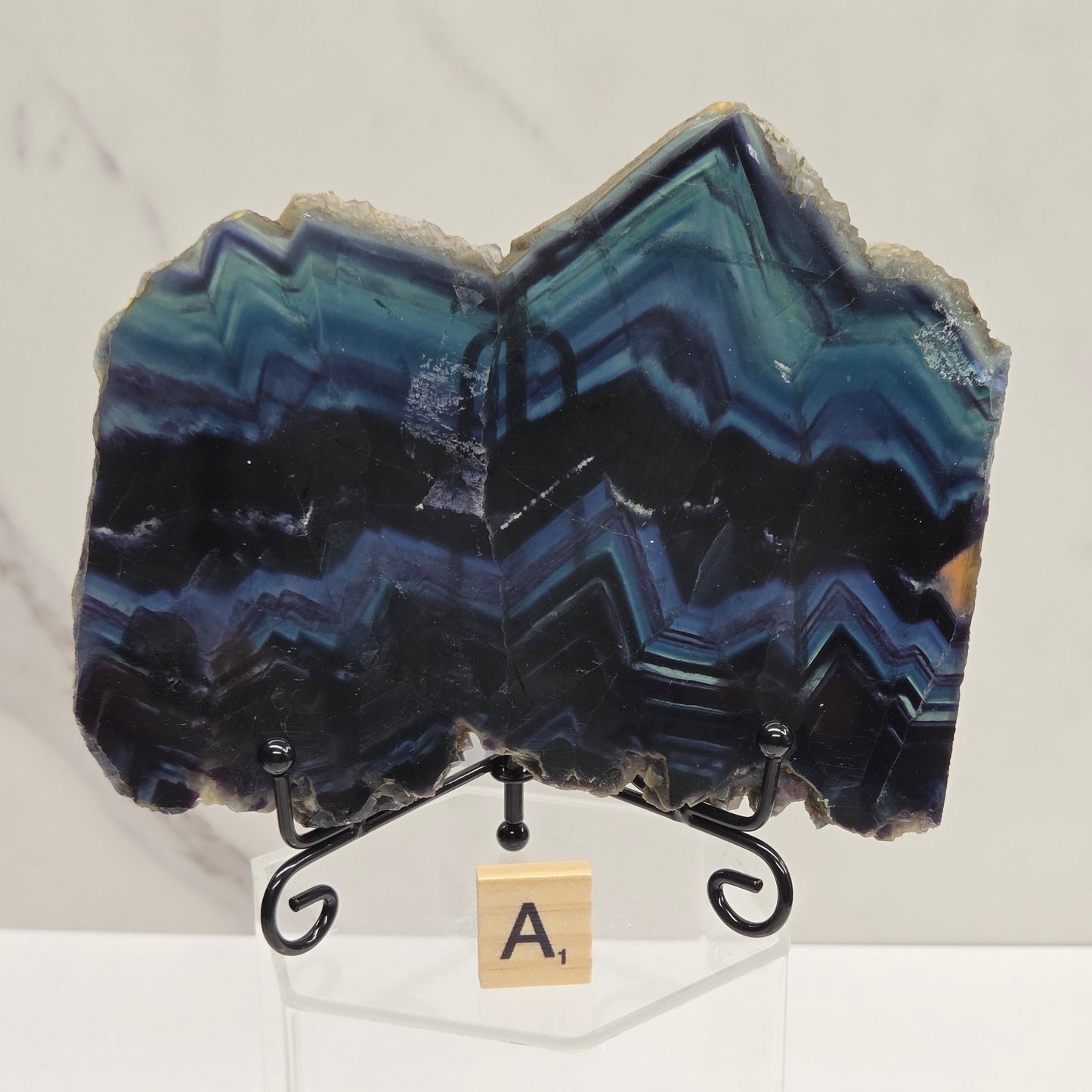 Banded fluorite slabs on a stand against a neutral background