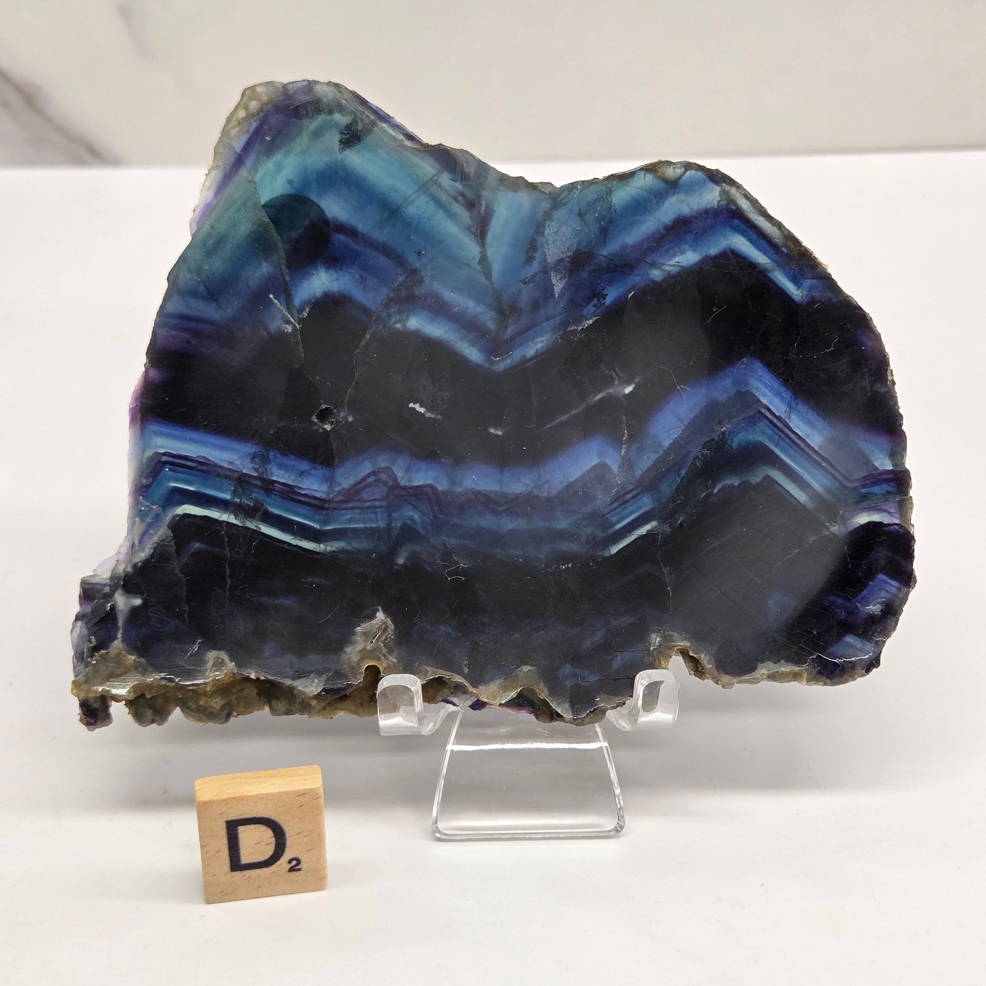 Banded fluorite slabs on a stand against a neutral background