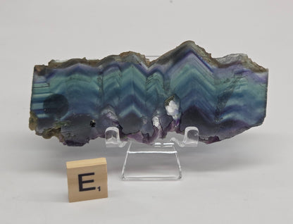Banded fluorite slabs on a stand against a neutral background