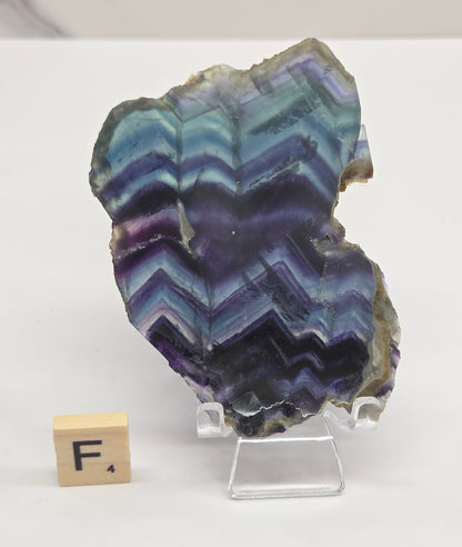 Banded fluorite slabs on a stand against a neutral background