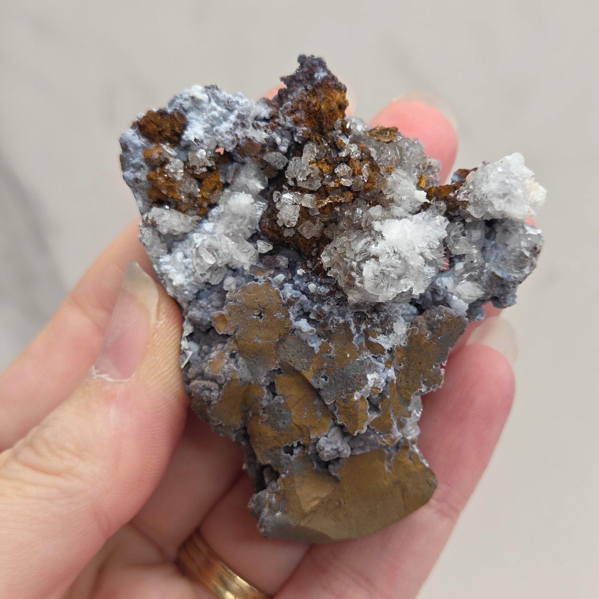 Mineral sample held in a hand with a blurred background
