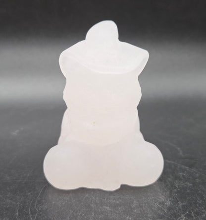 Light pink calcite cat with pumpkin carving on a black background