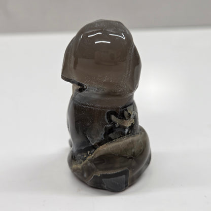 Carved stone figure of a dog on a white surface