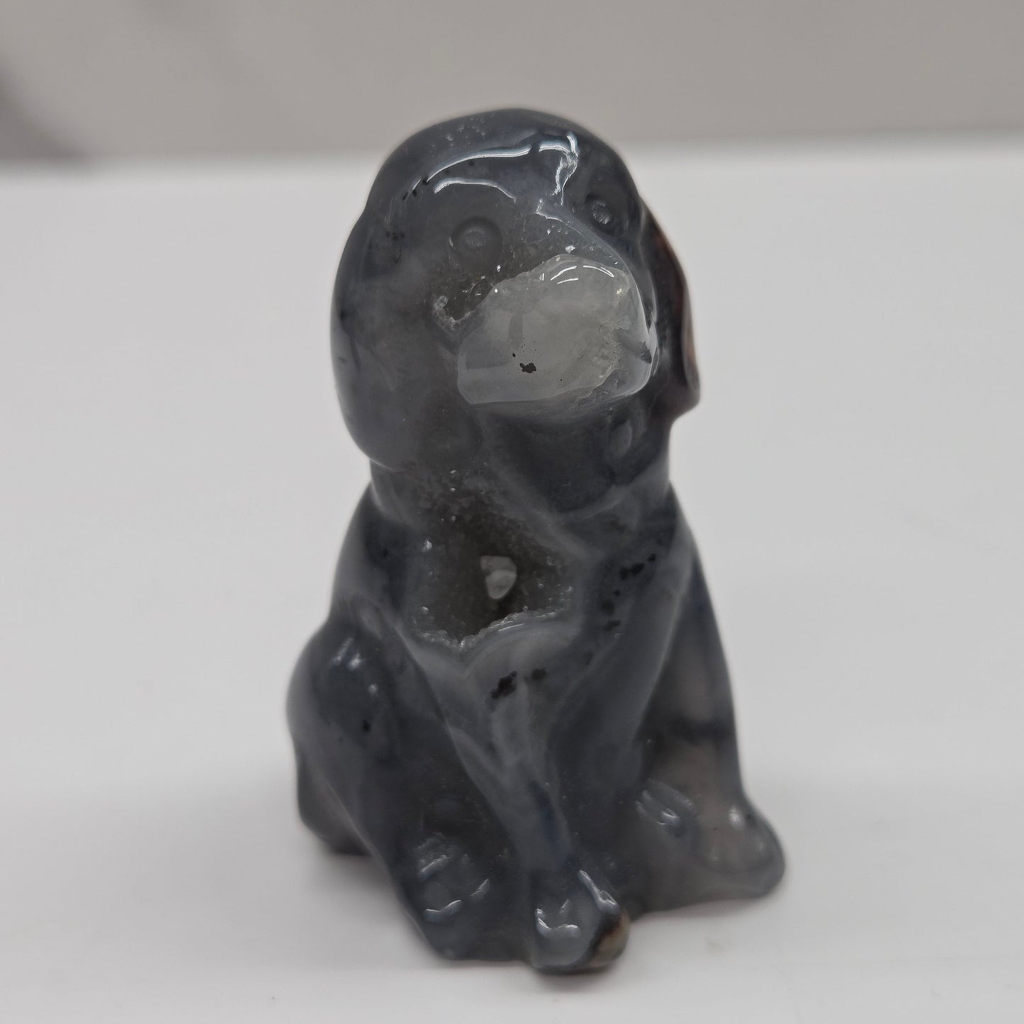 Gray stone sculpture of a dog on a white background