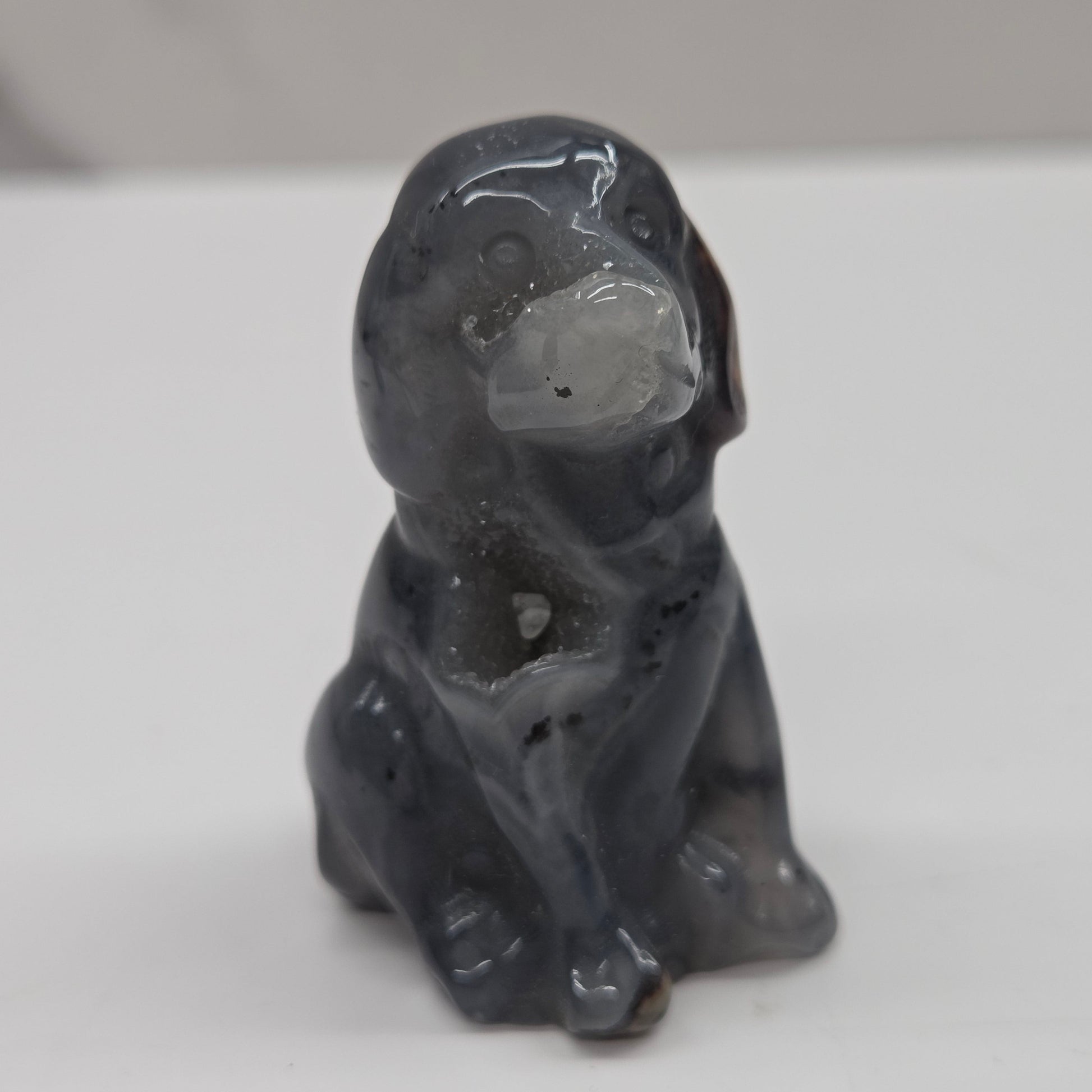 Gray stone sculpture of a dog on a white background