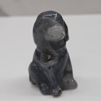 Gray stone sculpture of a dog on a white background