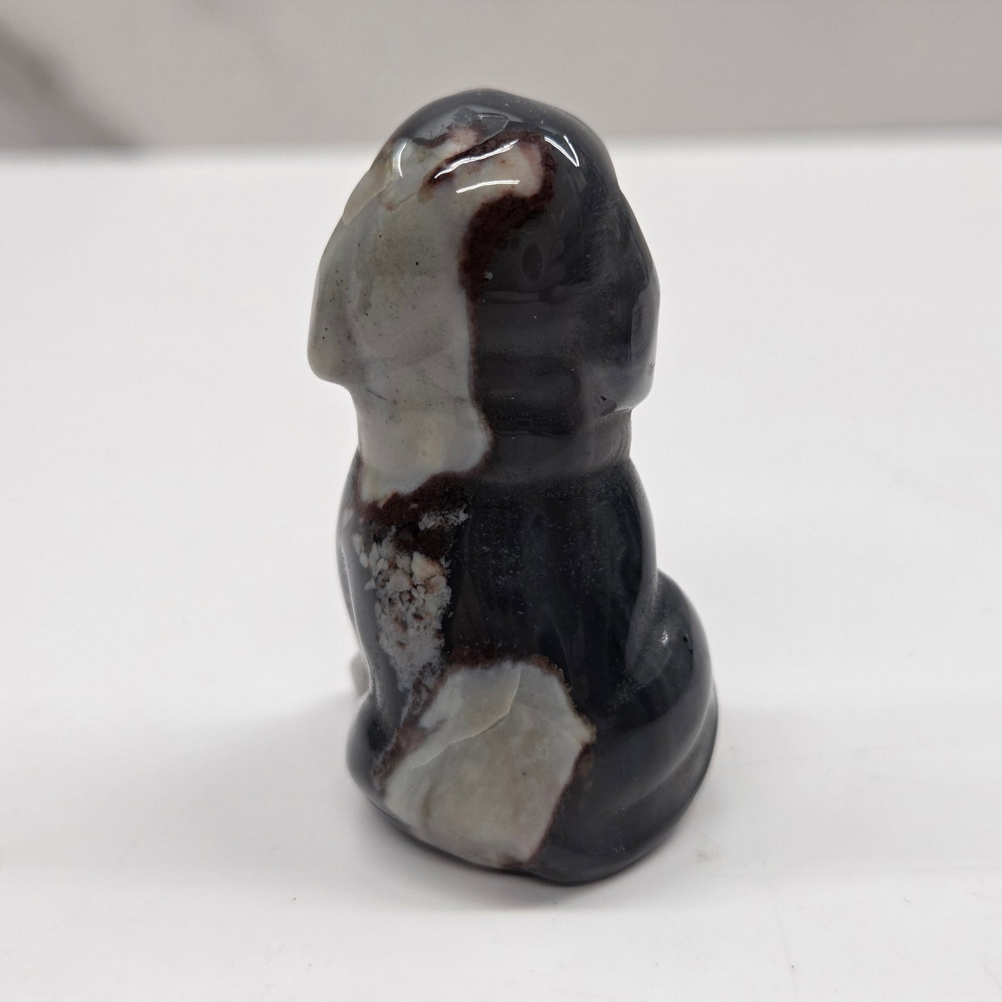 Decorative stone sculpture of a dog on a white surface