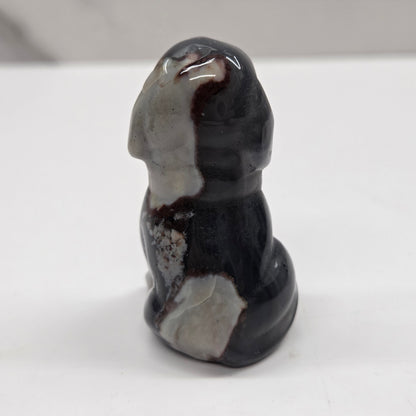 Decorative stone sculpture of a dog on a white surface