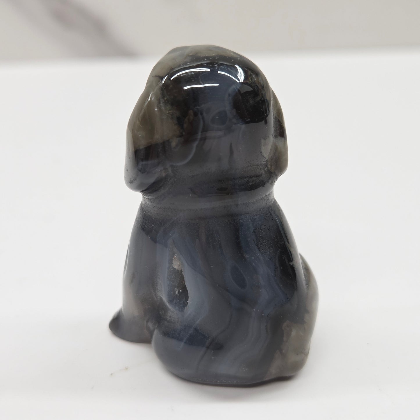 Gray stone sculpture of a dog on a white background