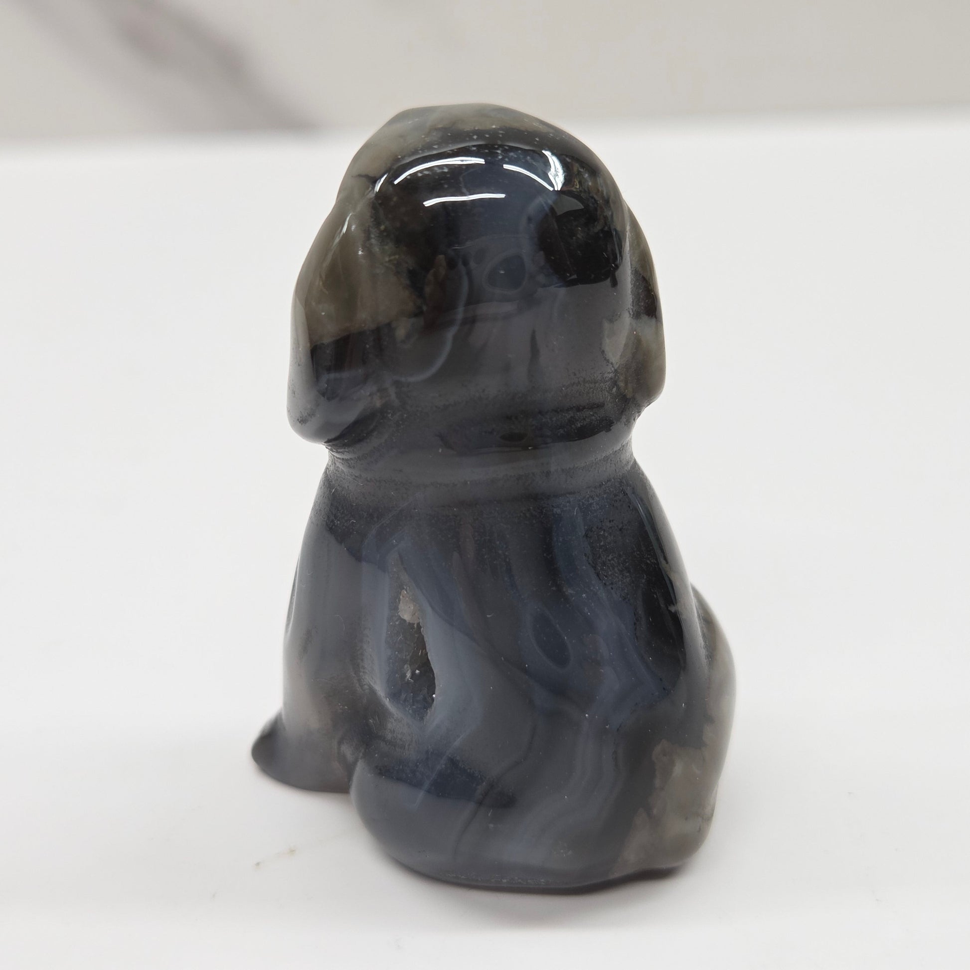 Gray stone sculpture of a dog on a white background
