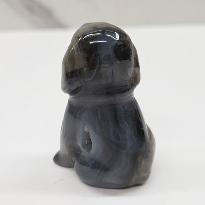 Gray stone sculpture of a dog on a white background