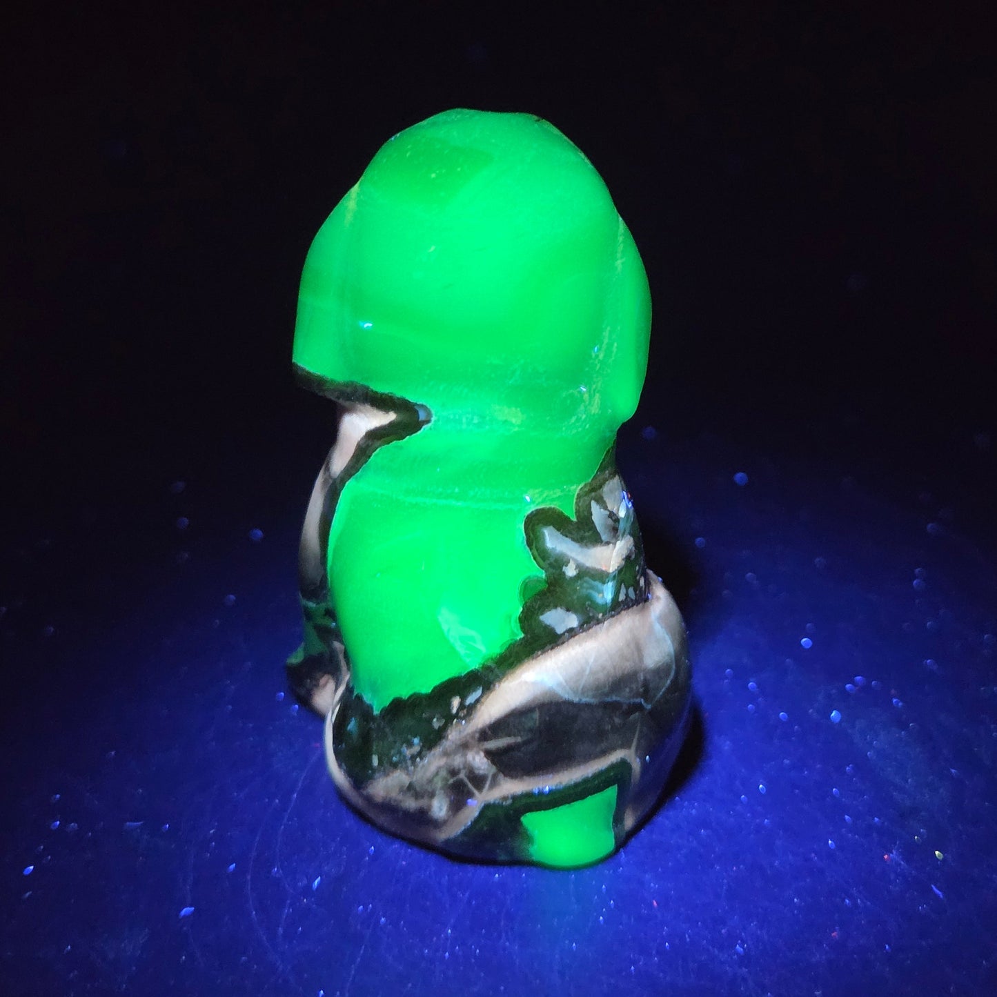 Stone dog carving under a UV lighting on a dark background