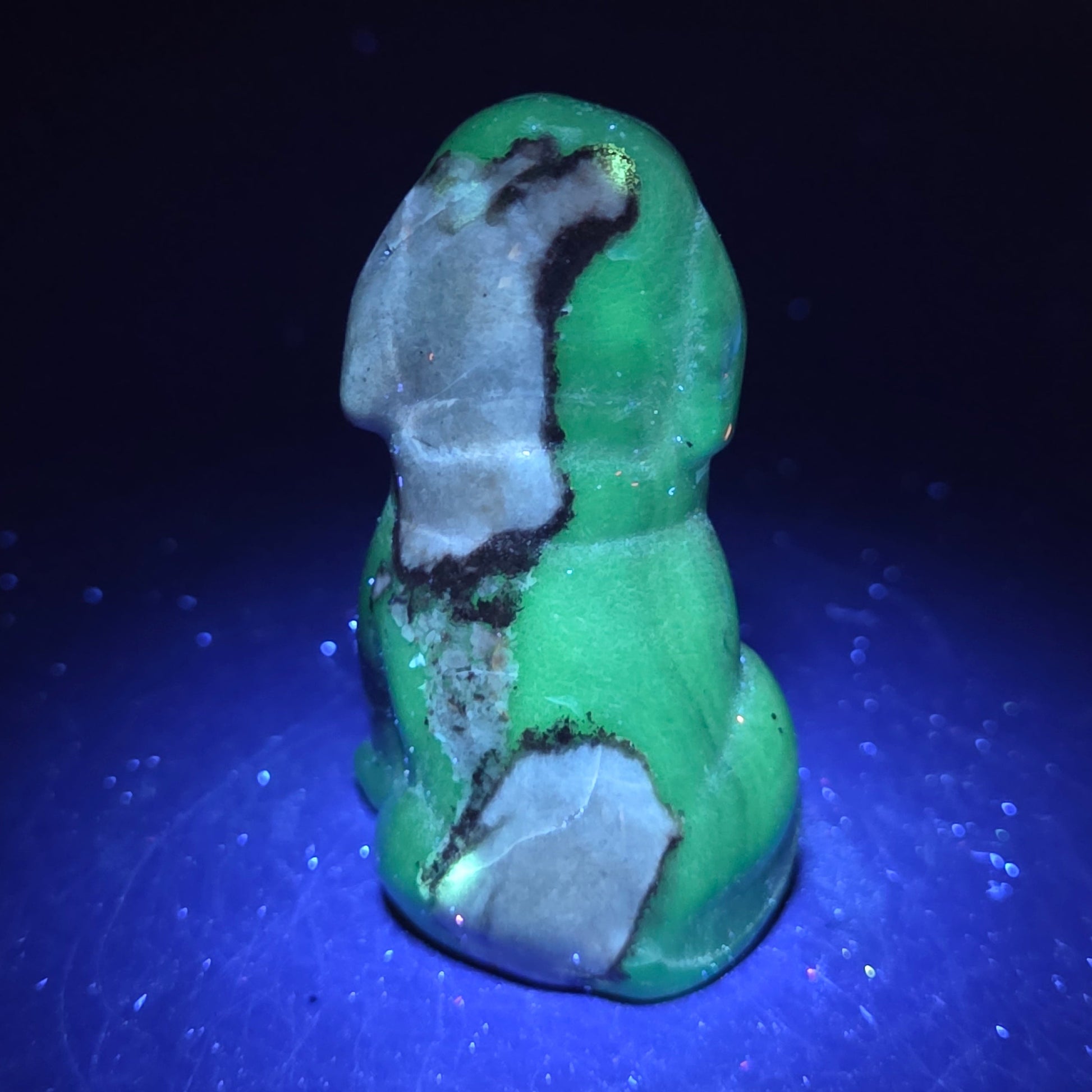 Stone dog carving under a UV lighting on a dark background