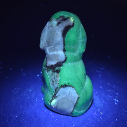 Stone dog carving under a UV lighting on a dark background
