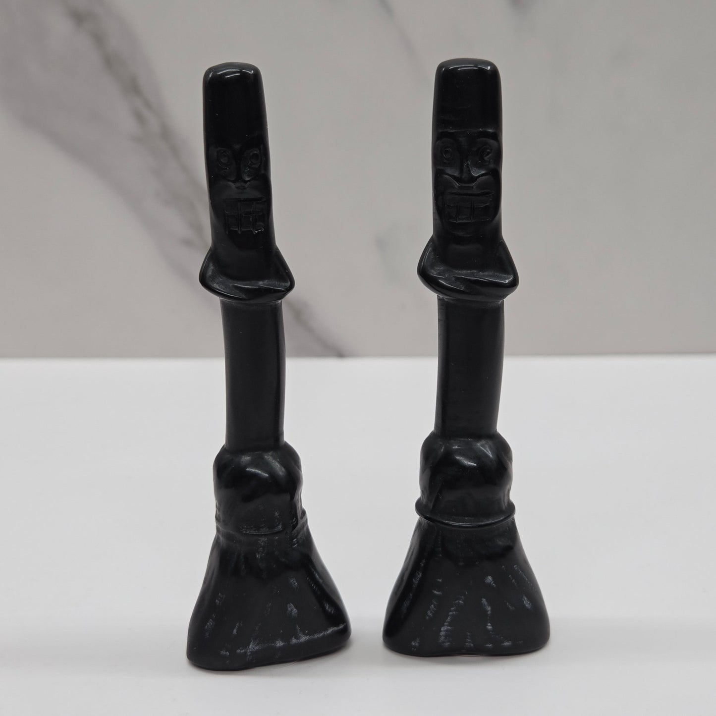 Obsidian broom carvings on a white background