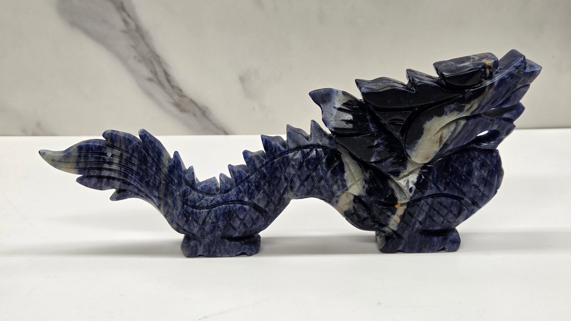 Blue and black chinese dragon carving on a white background