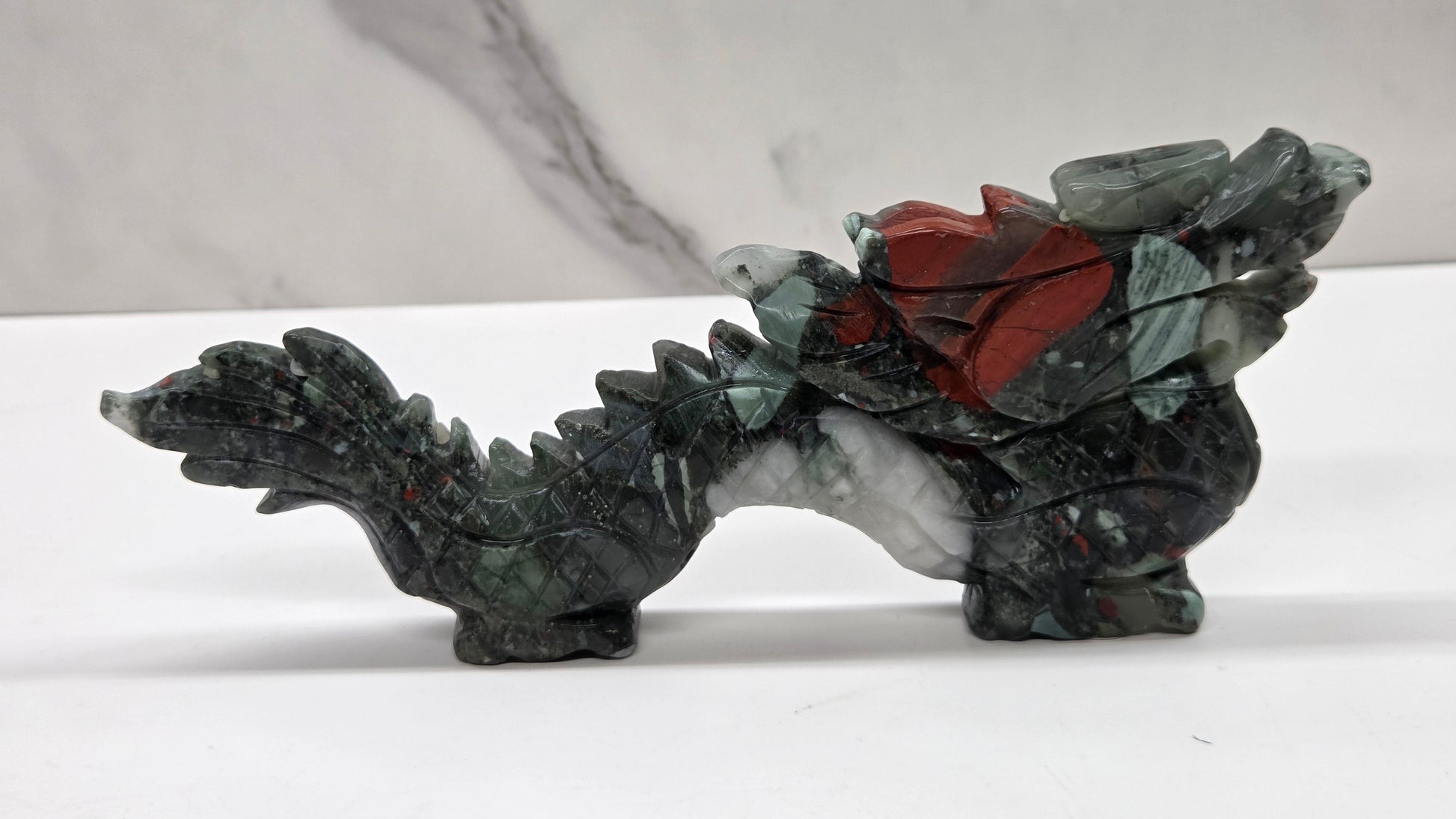 Grey and red chinese dragon carving on a white background