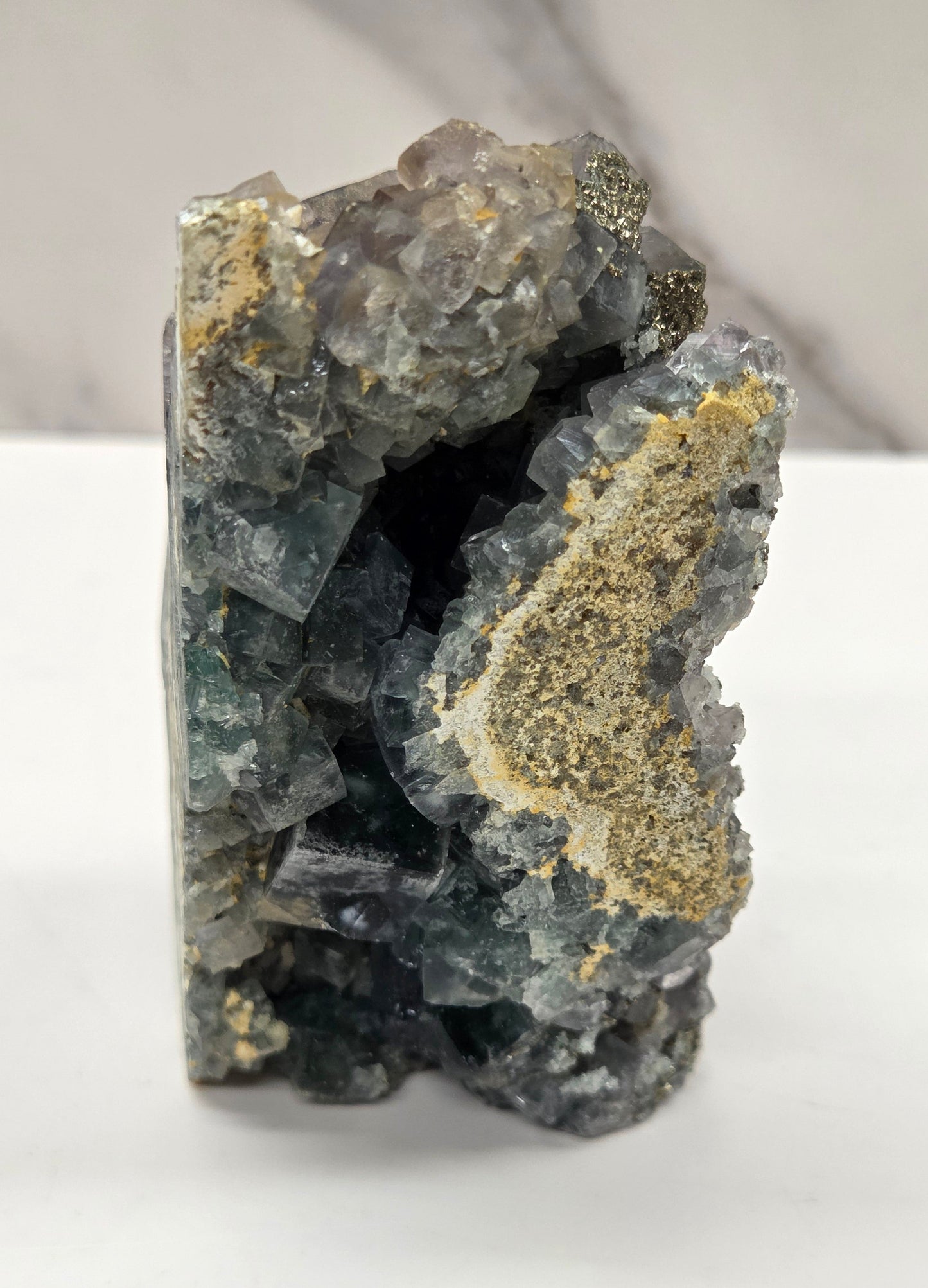 fluorite figurine with black eyes on a white surface and marble background