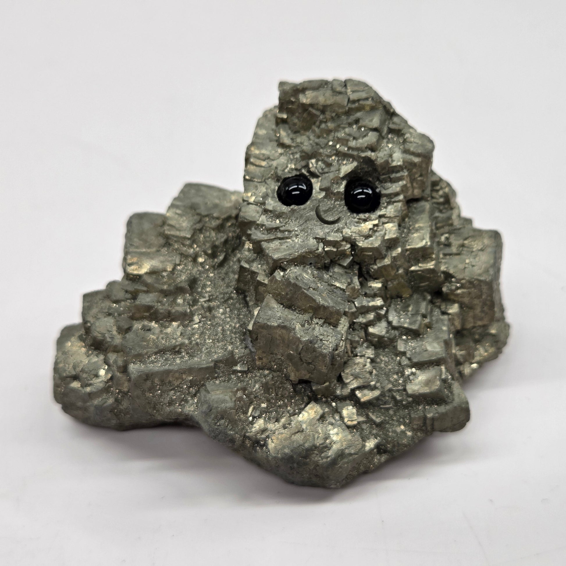 Mineral specimen with two black eyes on a white background