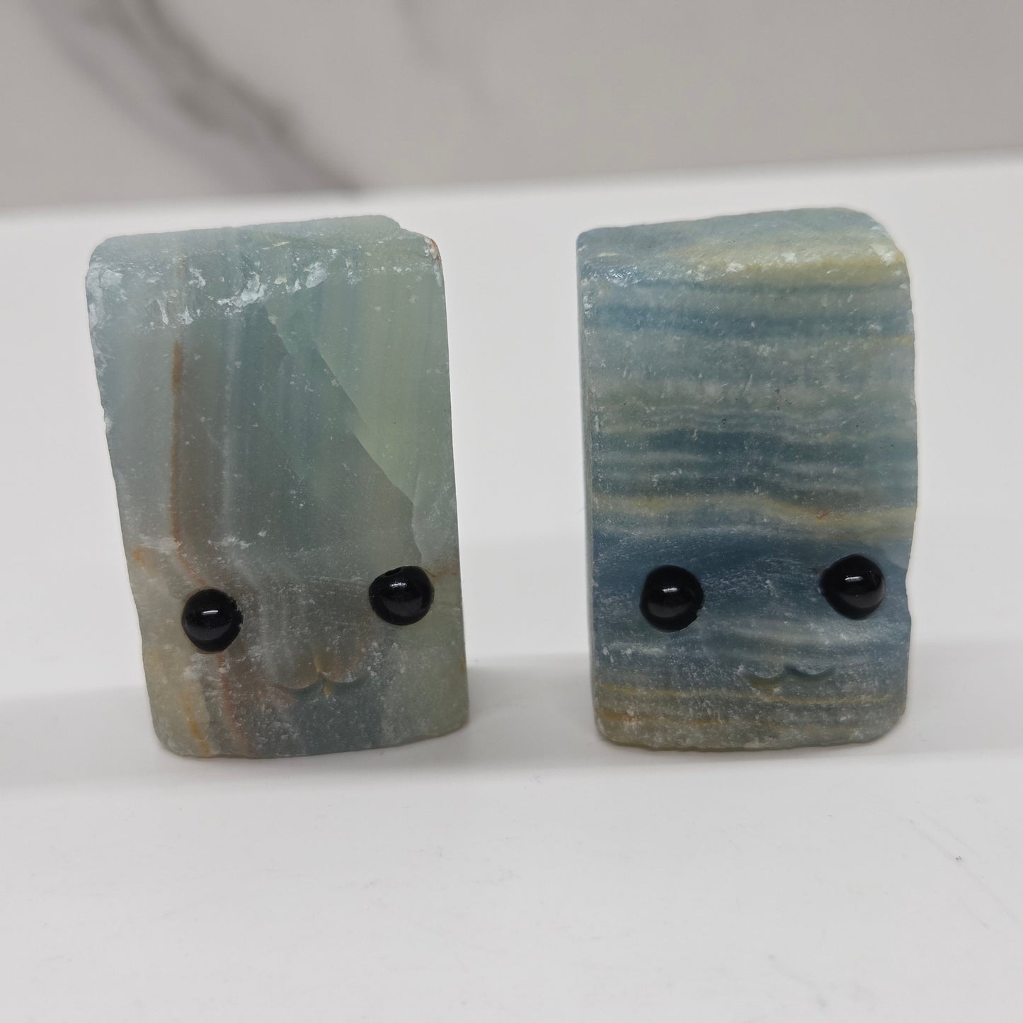 Blue Onyx with eyes and a mouth on a white background