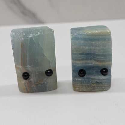 Blue Onyx with eyes and a mouth on a white background