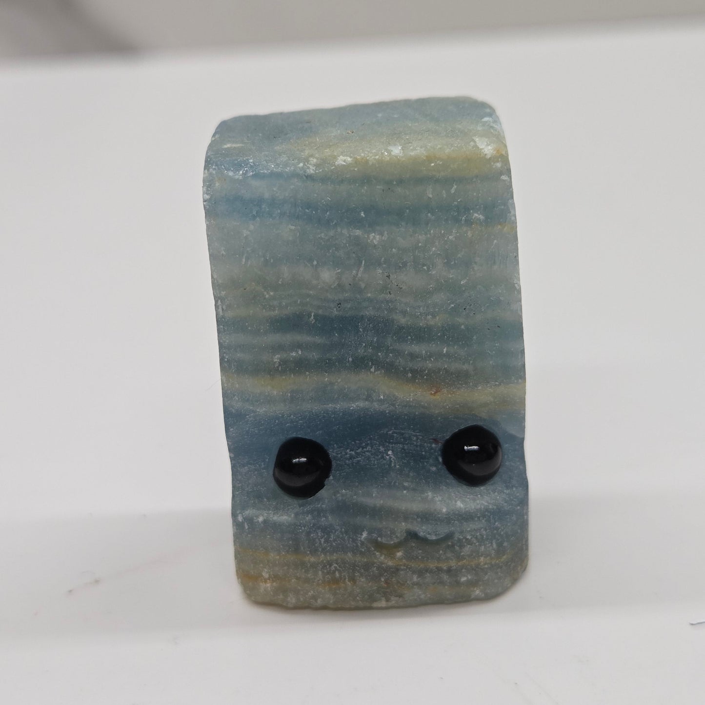 Blue Onyx with eyes and a mouth on a white background