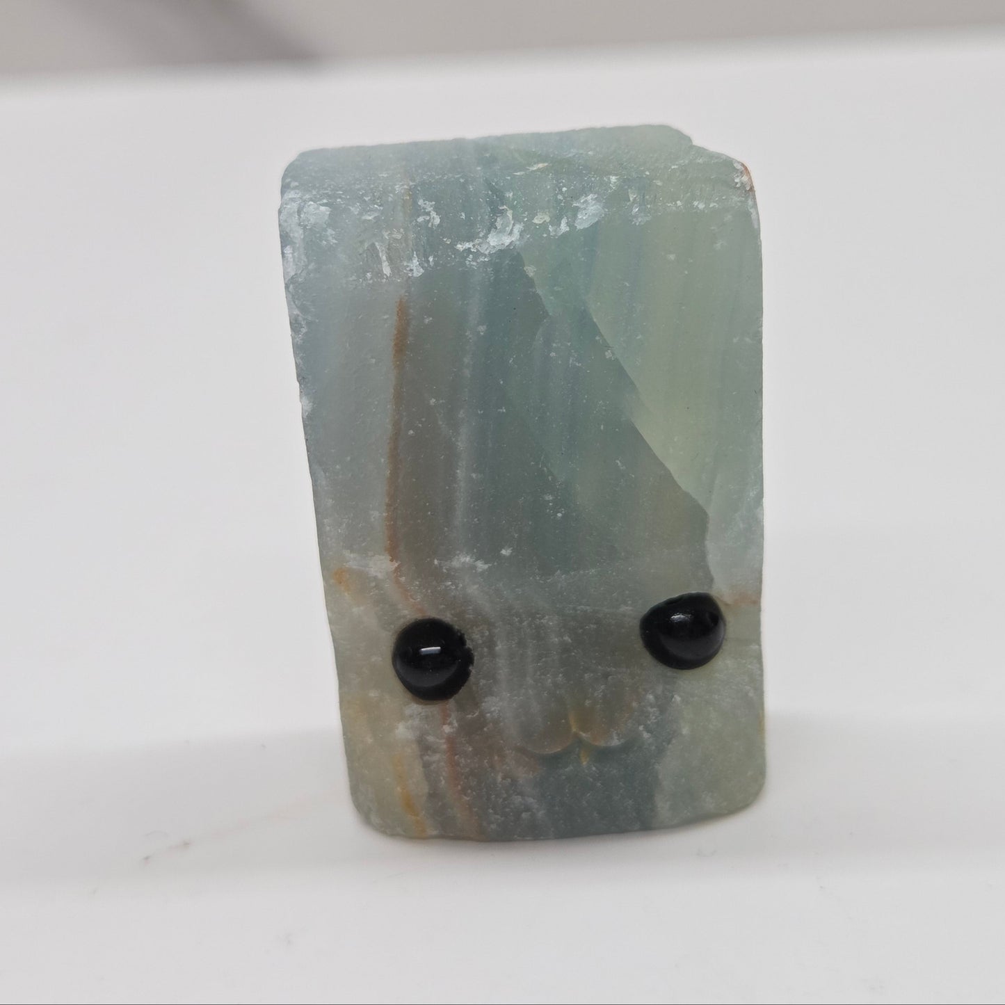 Blue Onyx with eyes and a mouth on a white background