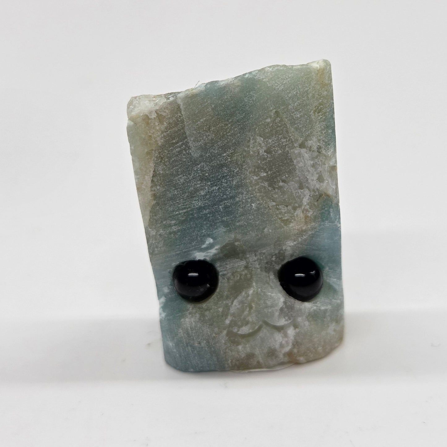 Caribbean Calcite with eyes and a mouth on a white background