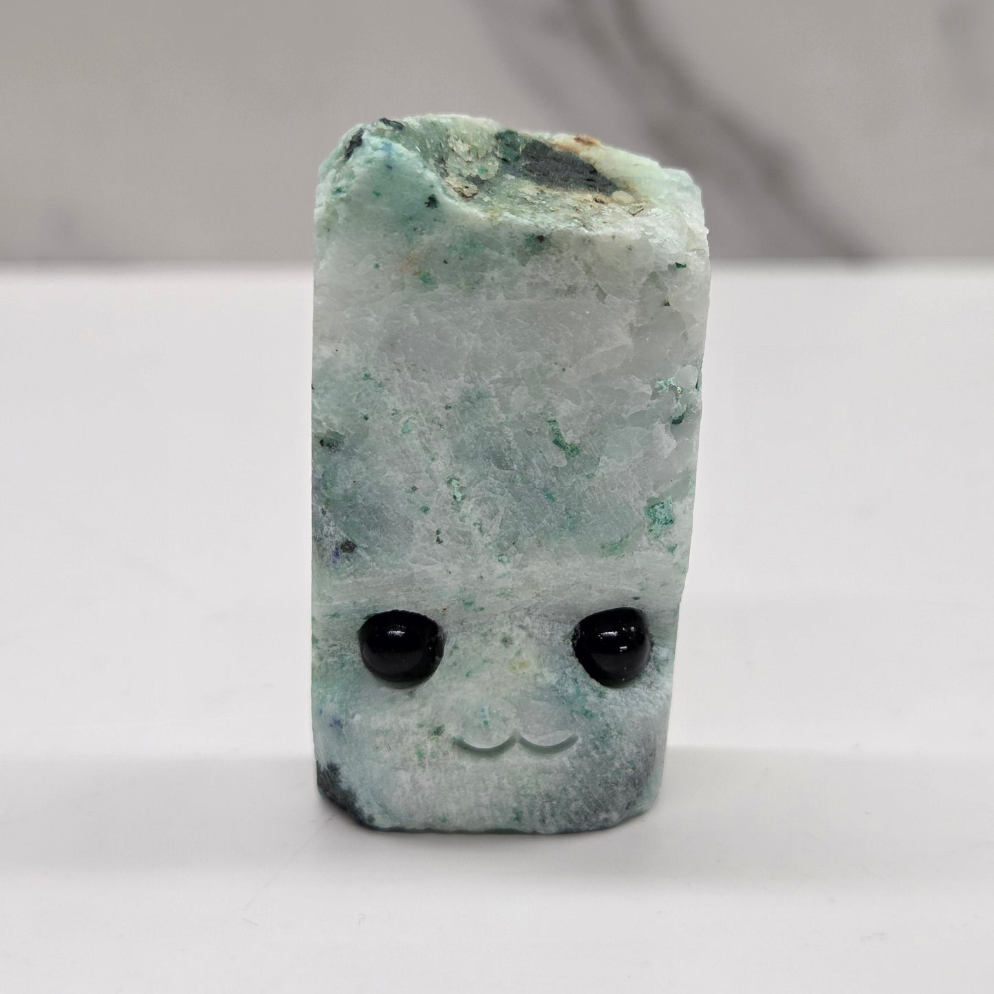 Phoenix Stone with eyes and a mouth on a white background